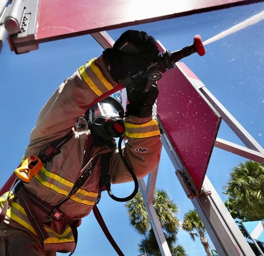 A photographer opens the hose nozzle to hit the target at the 2023 Firefighter Challenge World Championship. Photo by Jeffrey W Jones.