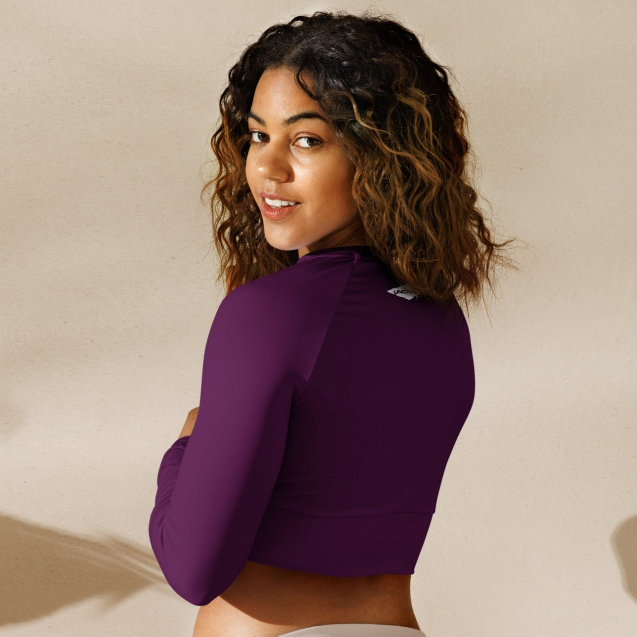 Dark Fuchsia long-sleeve crop top for women is made of recycled polyester and elastane, making it an eco-friendly choice for swimming, sports, or athleisure. UPF 50+.