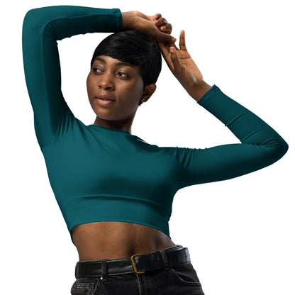 Teal long-sleeve crop top for women is made of recycled polyester and elastane, making it an eco-friendly choice for swimming, sports, or athleisure. UPF 50+.