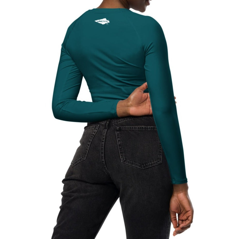 Teal long-sleeve crop top for women is made of recycled polyester and elastane, making it an eco-friendly choice for swimming, sports, or athleisure. UPF 50+.