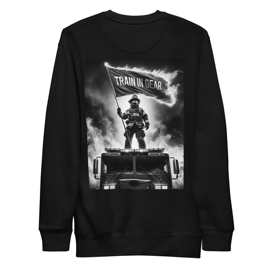 Train in Gear Firefighter graphic sweatshirt long sleeve in black. Black and white image of a firefighter standing on a fire truck, holding up a burning flag that reads "Train in Gear".